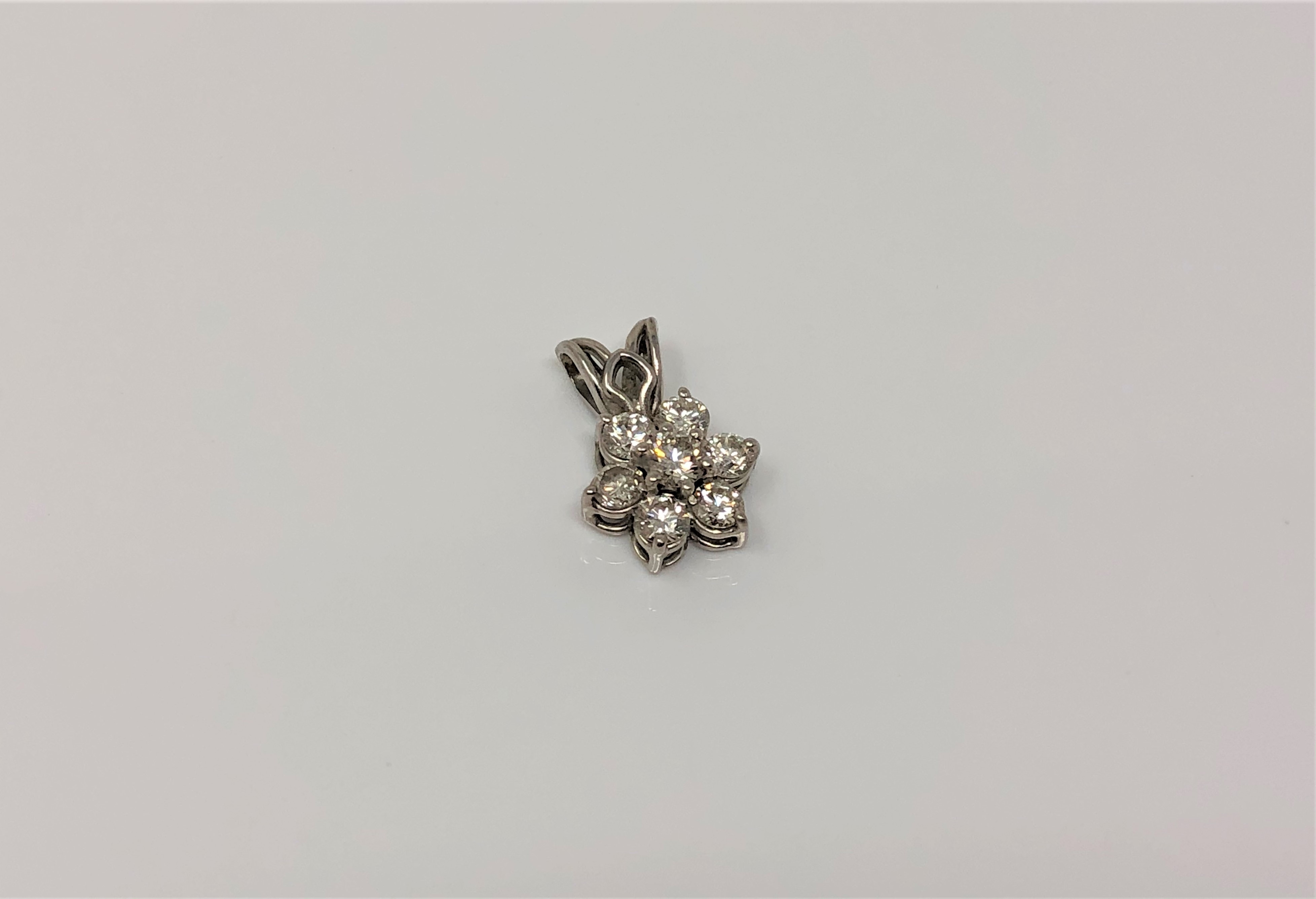 A white gold seven stone diamond cluster pendant, length 15mm CONDITION REPORT: 1.