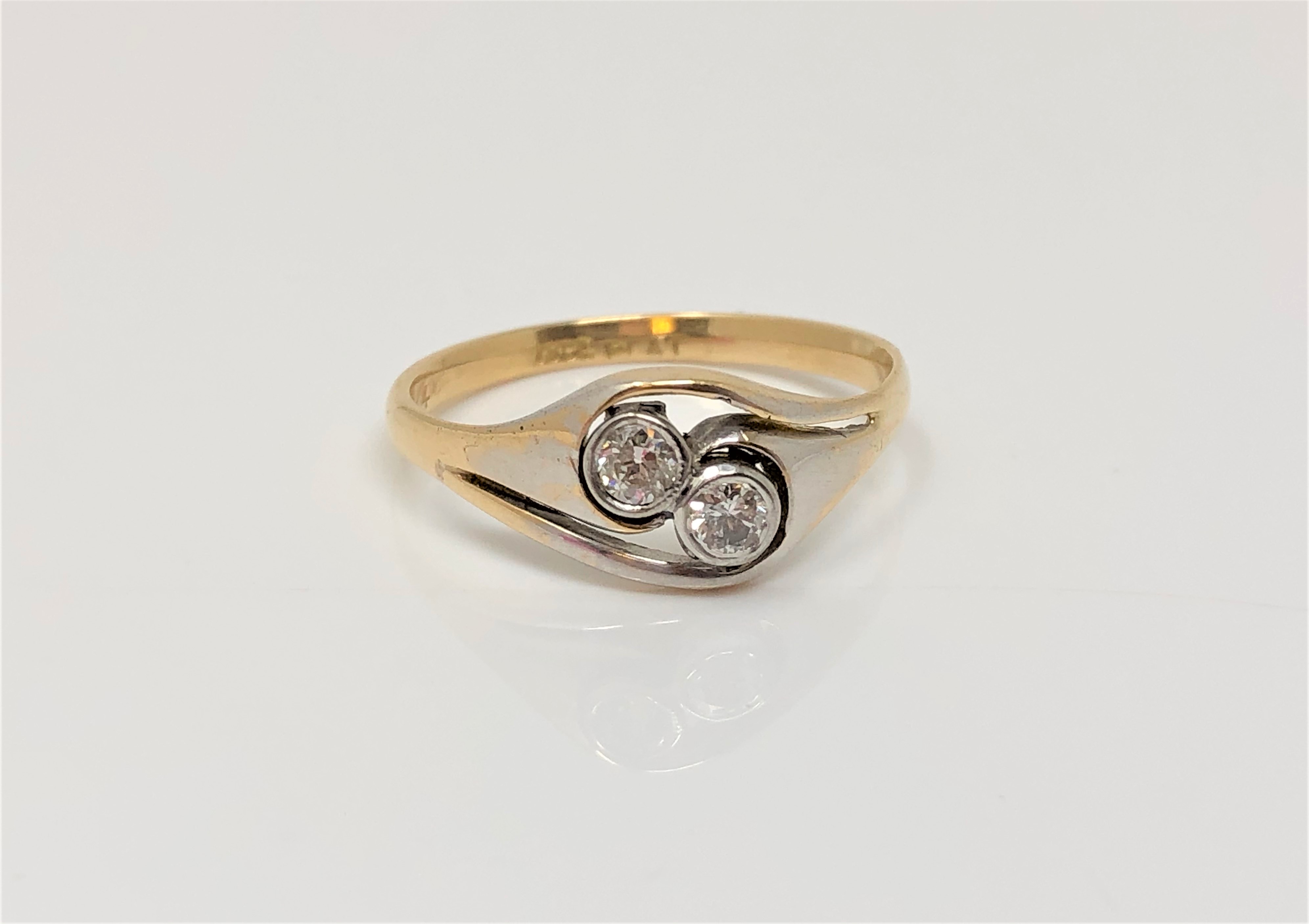 An 18ct gold and platinum two stone diamond ring, size P CONDITION REPORT: 2.
