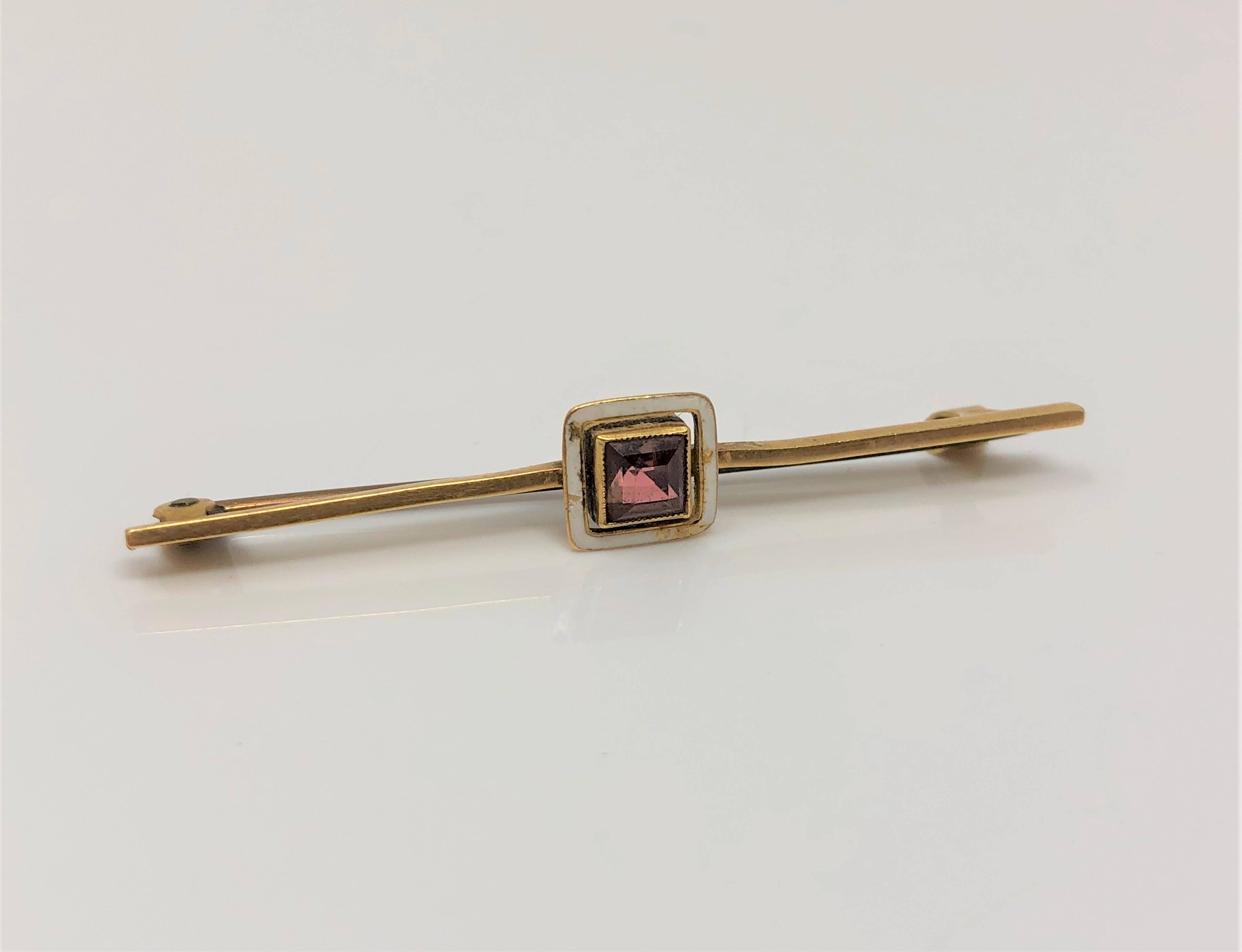 A yellow gold white enamelled and gem stone set pin CONDITION REPORT: 2g