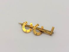 A 15ct gold horseshoe and riding crop brooch CONDITION REPORT: 1.