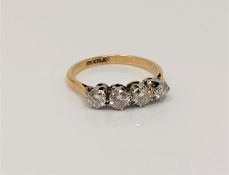 An 18ct gold and platinum four stone diamond ring, size N CONDITION REPORT: 2.