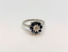 An 18ct white gold diamond and sapphire cluster ring, the central stone approximately 0.3ct, size M.