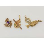 Four gold charms including an artist's palette set with emerald, amethyst,