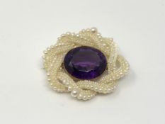 An antique amethyst and pearl brooch with gold fittings