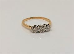 An 18ct gold three stone diamond ring, size M CONDITION REPORT: 2.