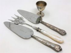 A Victorian silver egg cup and three items of silver mounted cutlery including toasting fork