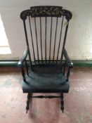 An antique painted spindle back rocking chair