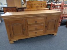 A hardwood double door sideboard fitted three central drawers CONDITION REPORT: