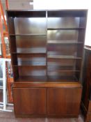 A set of 20th century Danish mahogany open bookshelves fitted double door cupboard beneath