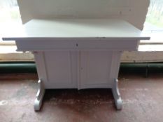 An antique painted pine clerk's desk fitted drawer and double door cupboards beneath
