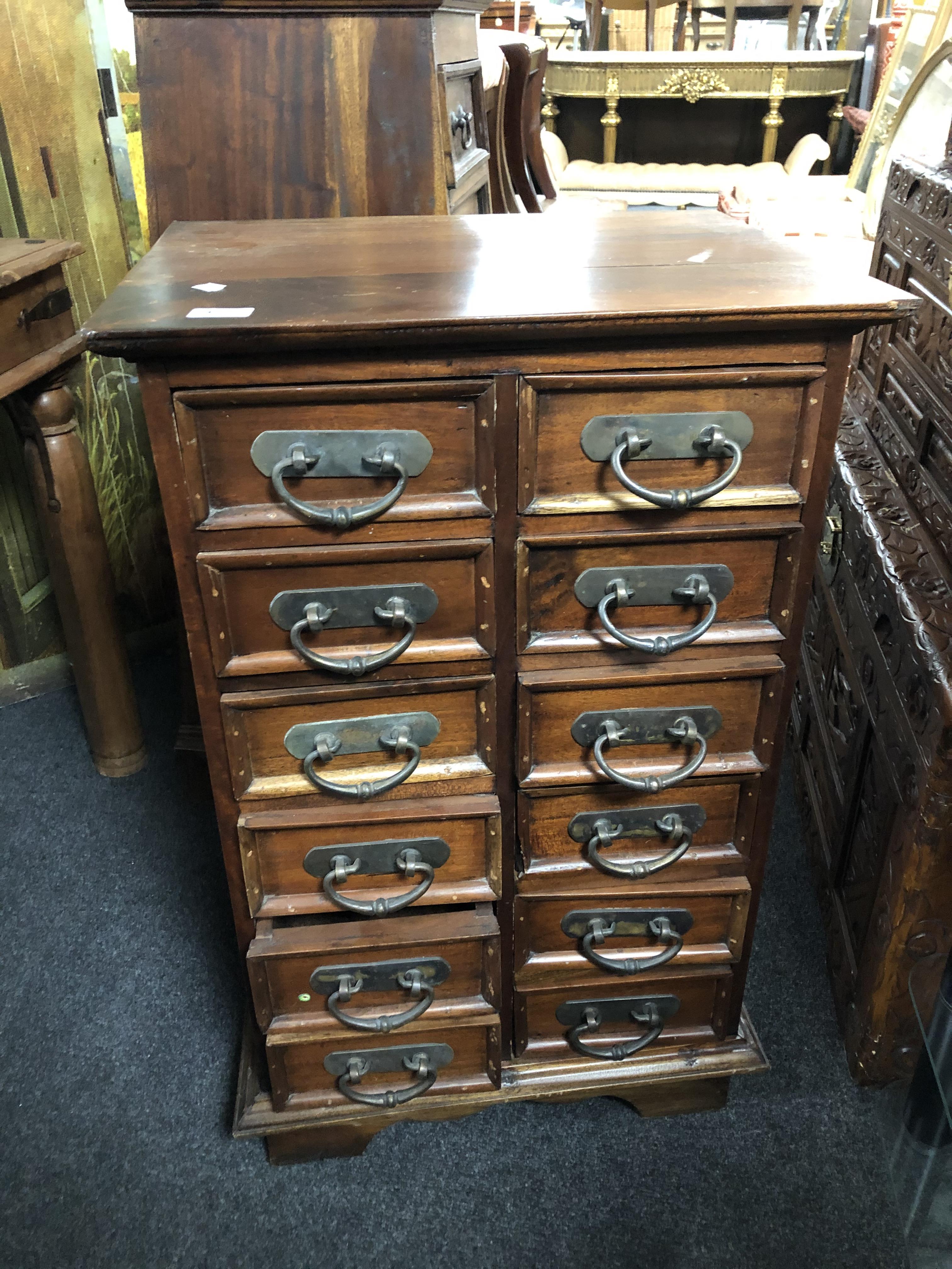 A sheesham wood twelve drawer chest with metal drop handles