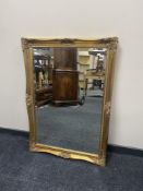 A bevel edged overmantel mirror in a swept frame