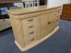 A contemporary bow-fronted double door eight drawer sideboard