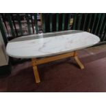 An oval marble effect coffee table on beech wood base