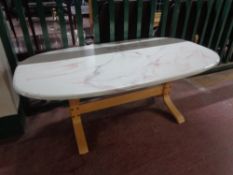 An oval marble effect coffee table on beech wood base