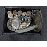 A crate of metal ware including serving trays, goblets,
