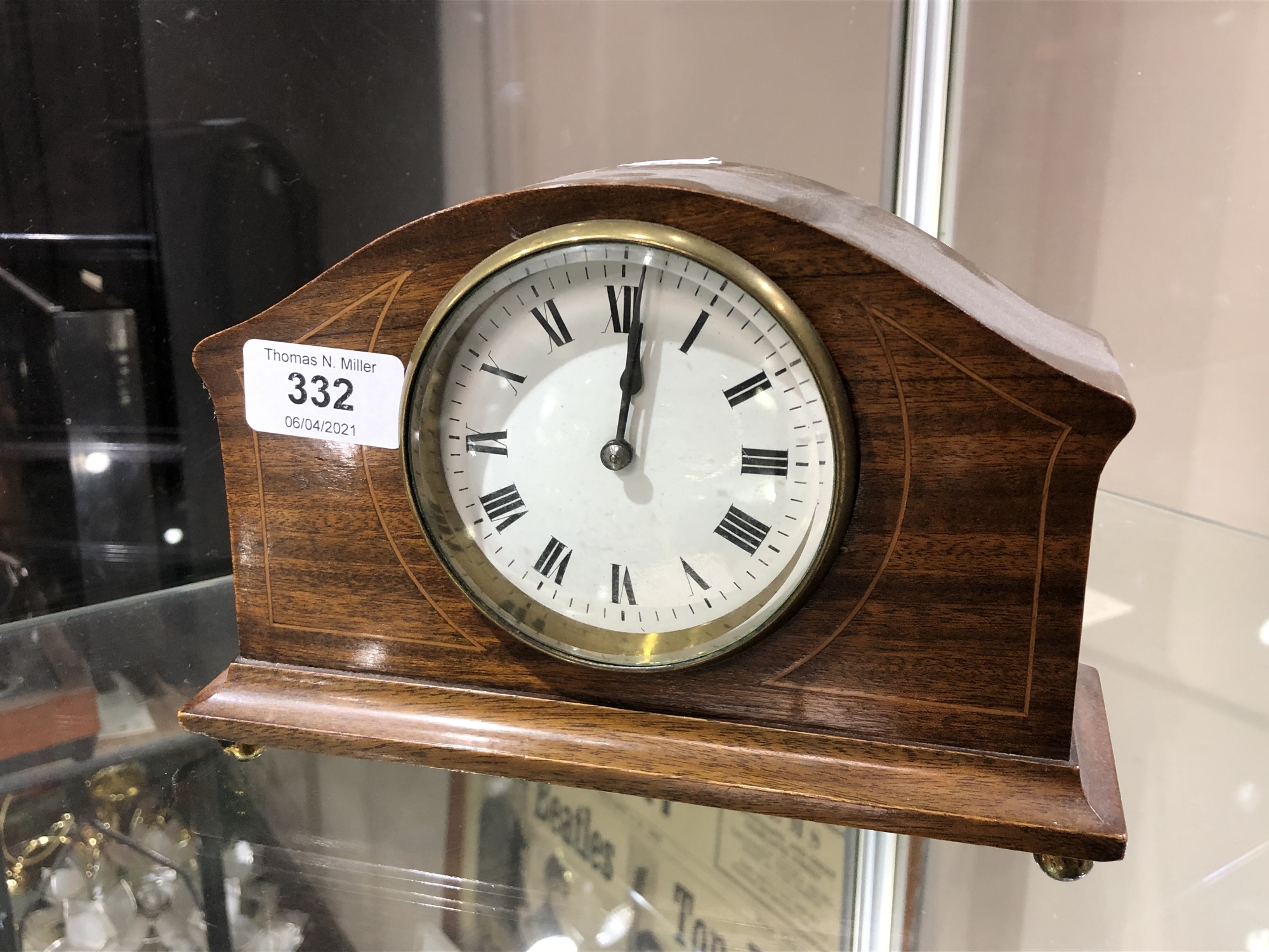 An early 20th century French inlaid mahogany mantel clock on raised brass feet