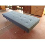 A mid 20th century day bed upholstered in a blue buttoned fabric,