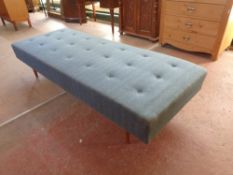 A mid 20th century day bed upholstered in a blue buttoned fabric,