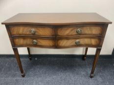 An inlaid mahogany serpentine fronted four drawer sideboard