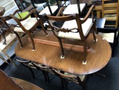 A Regency style inlaid mahogany twin pedestal dining table with leaf and eight dining chairs