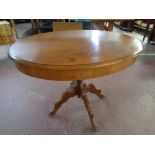 A 19th century oval oak pedestal occasional table on carved four-way support,