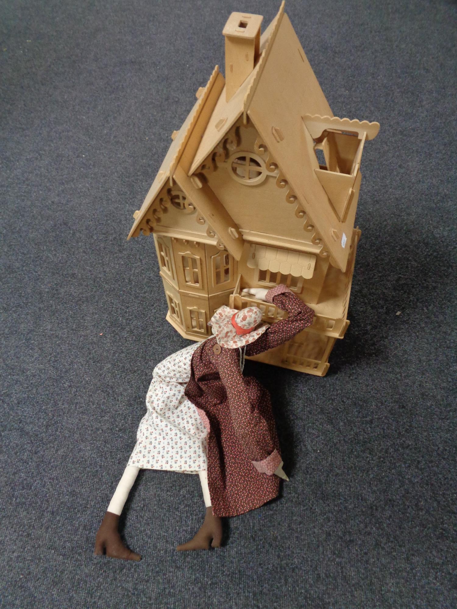 A cloth doll together with an unfinished wooden doll's house