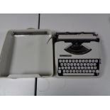 A cased Hermes Baby typewriter