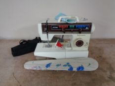 A Jones Buttonmatic electric sewing machine with foot pedal and accessories and a miniature ironing