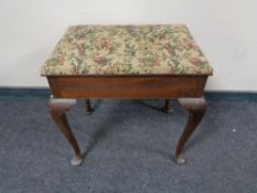 An Edwardian mahogany storage piano stool on cabriole legs