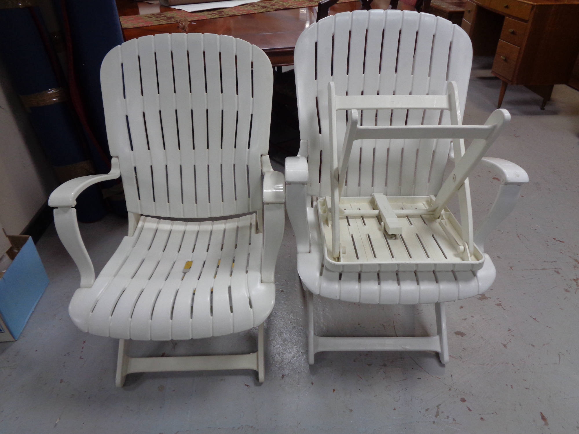 A pair of plastic garden armchairs and matching side table