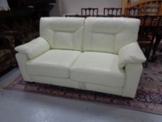 A cream leather two seater bed settee