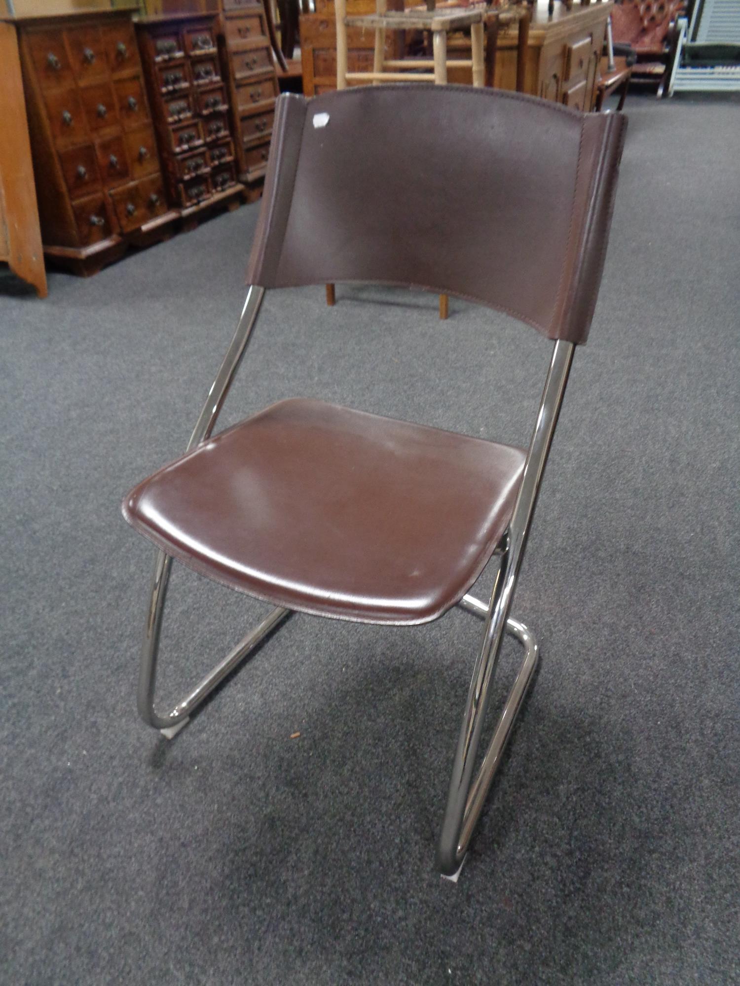 A contemporary tubular metal and brown vinyl dining chair