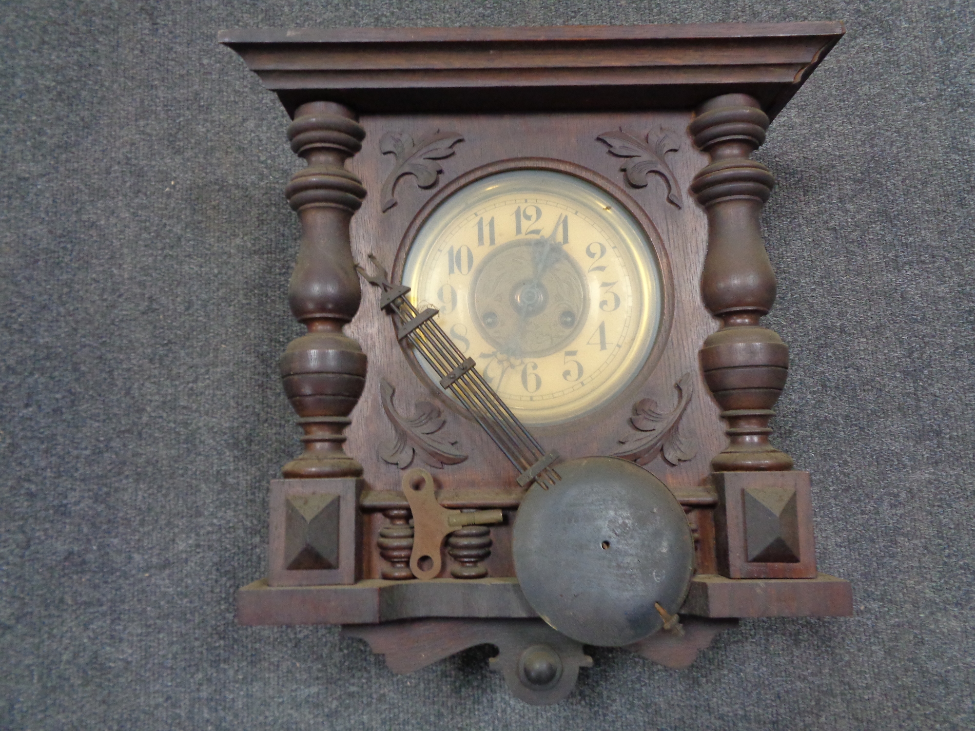 An early 20th century German wall clock with brass dial with pendulum and key (case a/f)