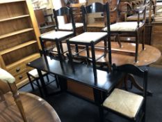 A contemporary black ash turnover top dining table and four rush seated chairs