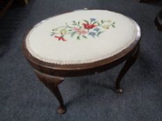 An oval tapestry upholstered dressing table stool on cabriole legs