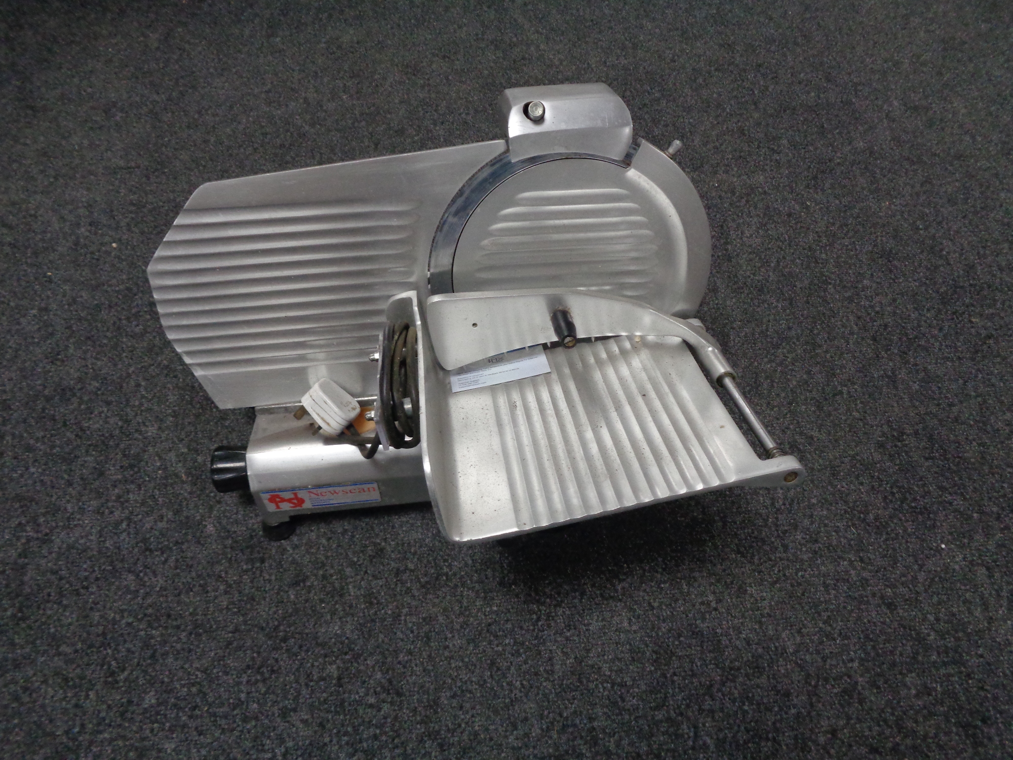 A Newscan stainless steel commercial meat slicer