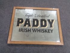 An Edwardian oak framed mirror bearing Paddy Irish Whiskey advertisement