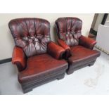 A pair of red leather button back armchairs