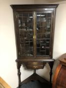 A 19th century oak double glazed door corner cabinet on raised legs