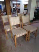 A set of four blond oak chairs upholstered in a striped fabric