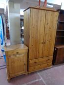 A pine double door wardrobe fitted two drawers beneath together with a pine side cabinet fitted a