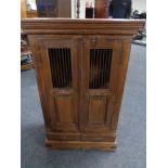 An eastern hardwood double door cabinet fitted two drawers beneath