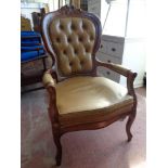 An Italianate stye armchair upholstered in buttoned leather