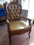 An Italianate stye armchair upholstered in buttoned leather