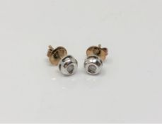 A pair of white gold CZ stud earrings with 9ct yellow gold backings.