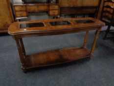 A contemporary two tier console table with three glass inset panels in a walnut finish