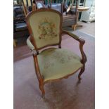 A beech framed French style salon armchair upholstered in a tapestry fabric