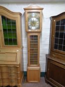 A blond oak Tempus Fugit longcase clock with pendulum and weights