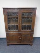 A Jaycee Oak double door leaded glass bookcase fitted cupboards beneath